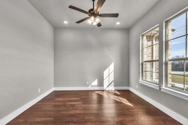 empty room with plenty of natural light, ceiling fan, and dark hardwood / wood-style flooring