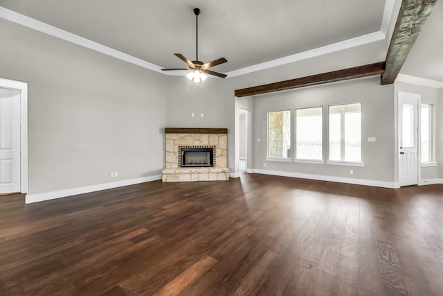 unfurnished living room with ceiling fan, dark hardwood / wood-style flooring, beamed ceiling, a fireplace, and ornamental molding