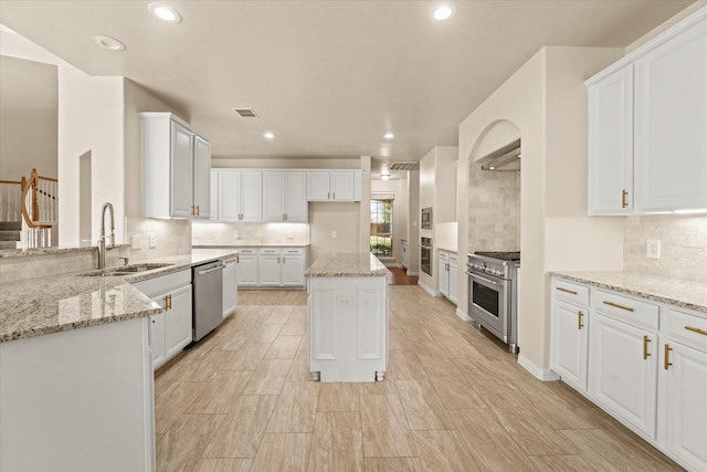 kitchen featuring light stone counters, sink, white cabinets, and appliances with stainless steel finishes