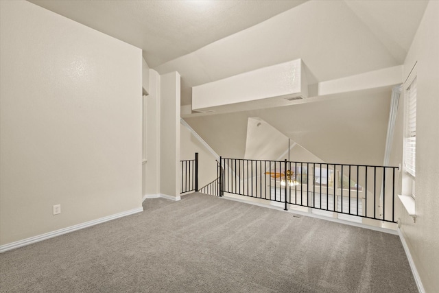 unfurnished room with carpet flooring and lofted ceiling