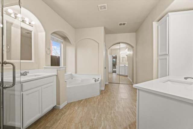 bathroom featuring a washtub and vanity