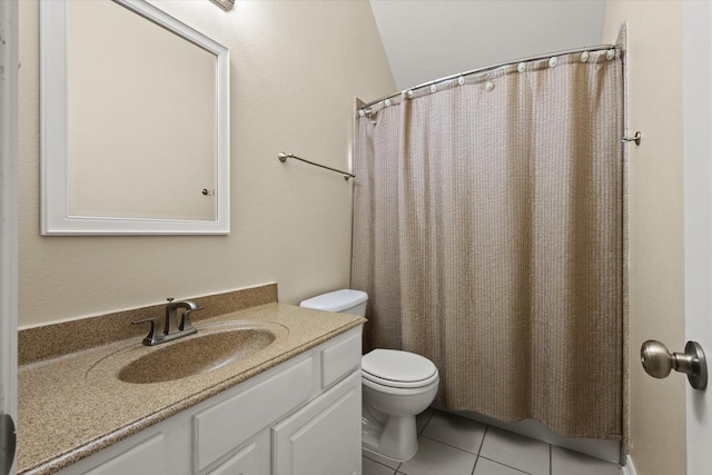 bathroom with tile patterned flooring, vanity, toilet, and lofted ceiling