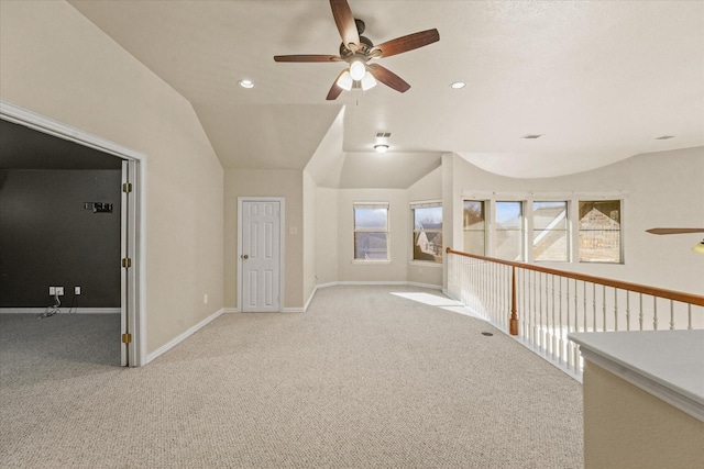 corridor with light colored carpet and lofted ceiling