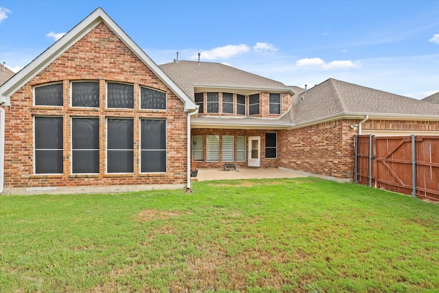 rear view of house with a yard and a patio