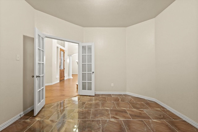 unfurnished room featuring french doors