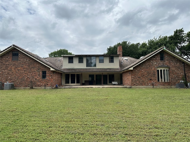 rear view of property with a patio area, a yard, and cooling unit