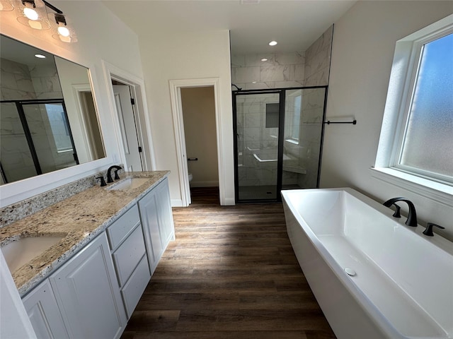 full bathroom featuring hardwood / wood-style floors, toilet, vanity, and shower with separate bathtub