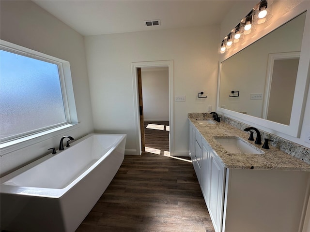 bathroom featuring a bathtub, vanity, and wood-type flooring