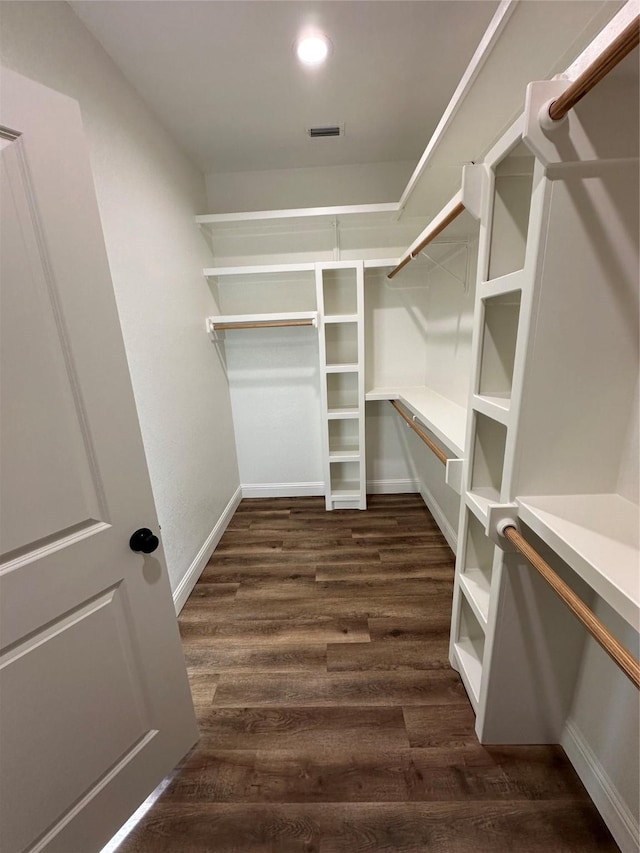 walk in closet with dark hardwood / wood-style floors