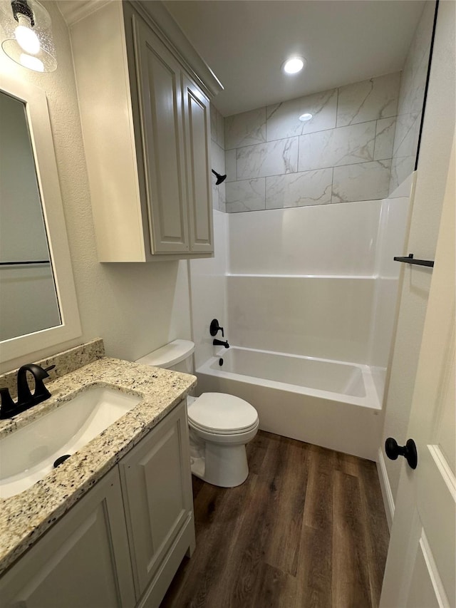 full bathroom featuring toilet, tiled shower / bath, vanity, and hardwood / wood-style floors