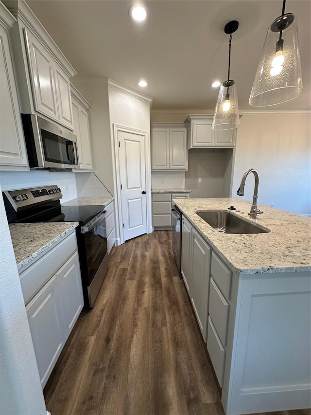 kitchen featuring stainless steel appliances, dark hardwood / wood-style floors, a kitchen island with sink, hanging light fixtures, and sink