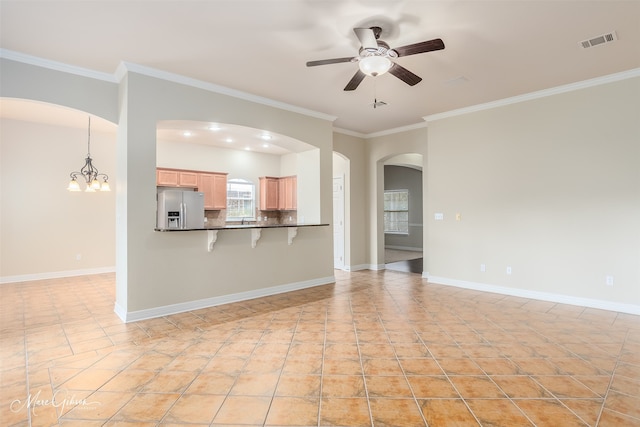 unfurnished living room with ceiling fan with notable chandelier, light tile patterned flooring, ornamental molding, and sink