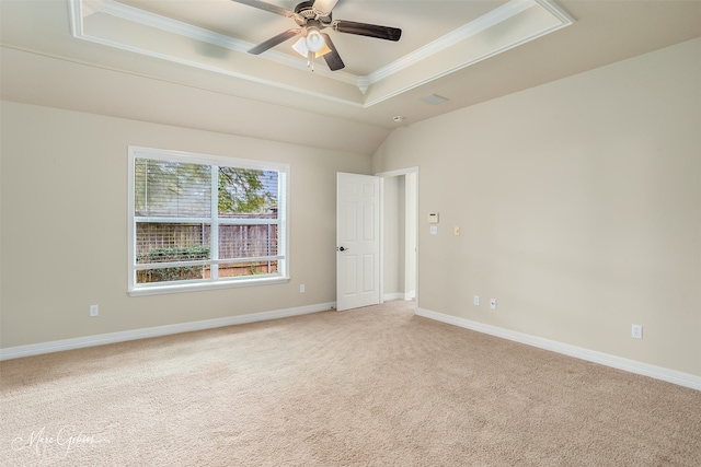 carpeted empty room with ceiling fan, crown molding, and a tray ceiling