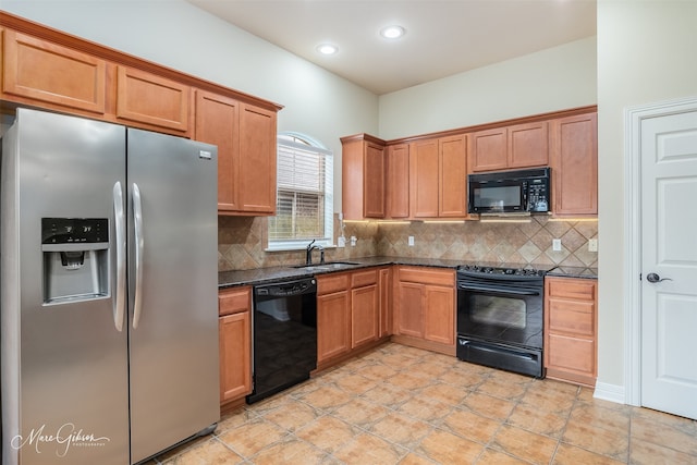 kitchen with dark stone counters, decorative backsplash, sink, and black appliances