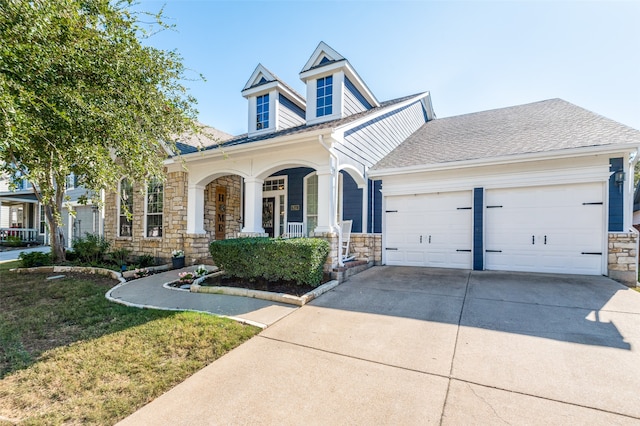 view of front facade with a porch, a garage, and a front yard