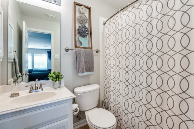 bathroom featuring walk in shower, vanity, and toilet