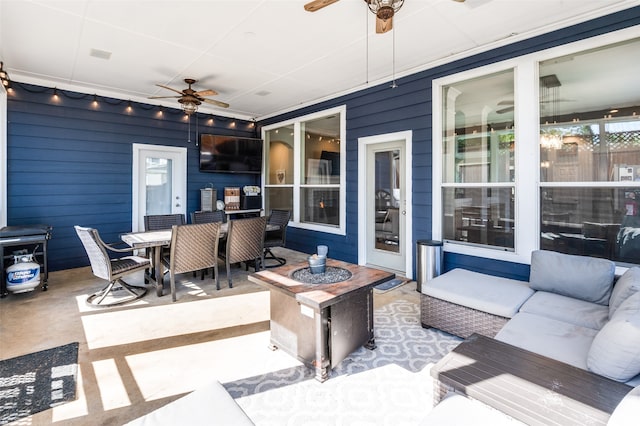 view of patio with ceiling fan and an outdoor living space with a fire pit