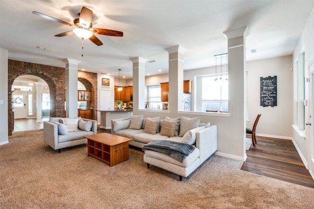 living room with decorative columns, ceiling fan, and hardwood / wood-style flooring