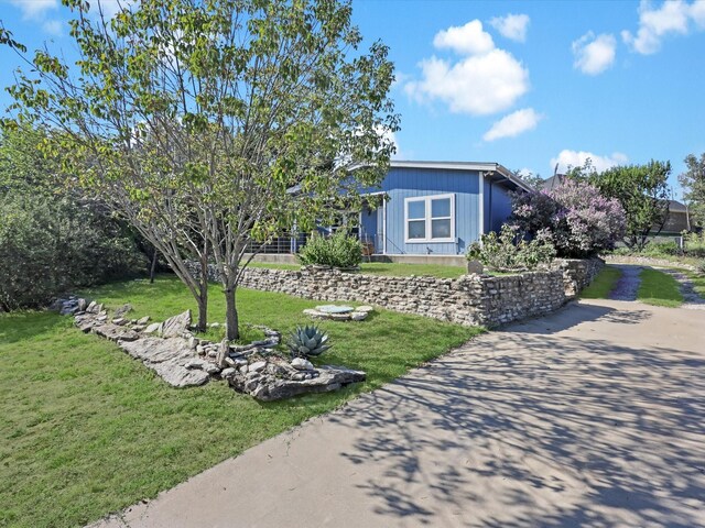 view of front of house featuring driveway and a front yard