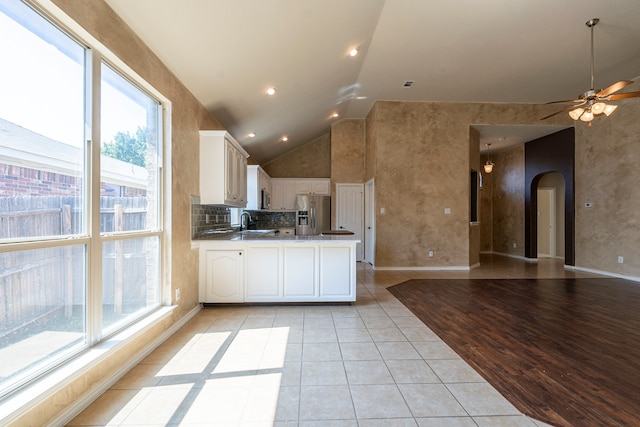 kitchen with light wood-type flooring, white cabinets, stainless steel appliances, and a wealth of natural light