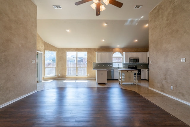 kitchen featuring white cabinets, ceiling fan, appliances with stainless steel finishes, and light wood-type flooring