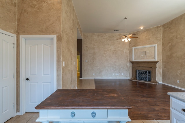 kitchen featuring ceiling fan, white cabinets, light wood-type flooring, and wood counters