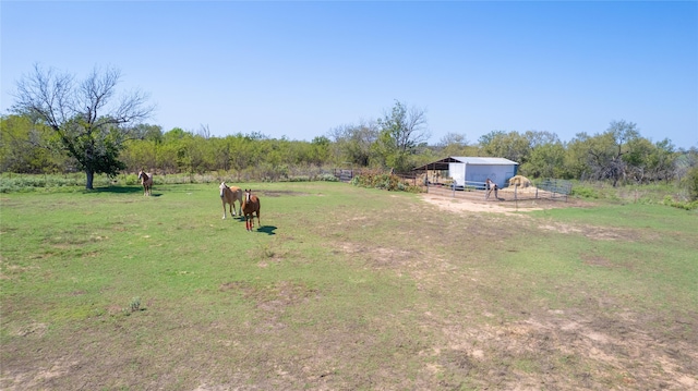 view of yard with a rural view and an outbuilding