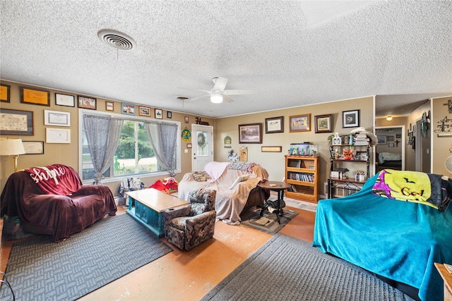 living room featuring a textured ceiling, concrete floors, and ceiling fan