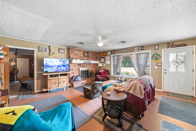 living room featuring a textured ceiling, ceiling fan, and a brick fireplace