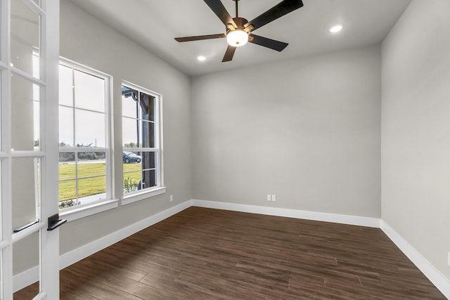 spare room with dark hardwood / wood-style flooring and ceiling fan