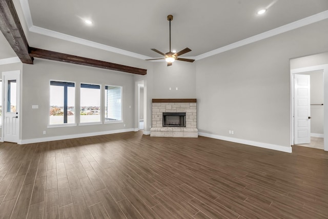 unfurnished living room with a stone fireplace, ceiling fan, crown molding, and dark hardwood / wood-style floors