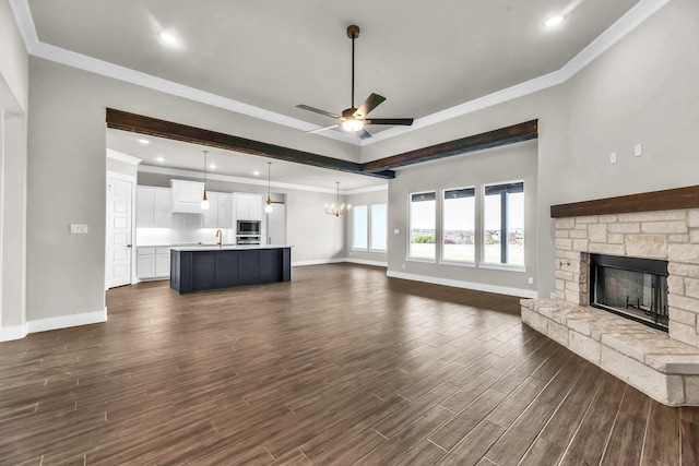 unfurnished living room featuring dark hardwood / wood-style floors, ornamental molding, and a fireplace