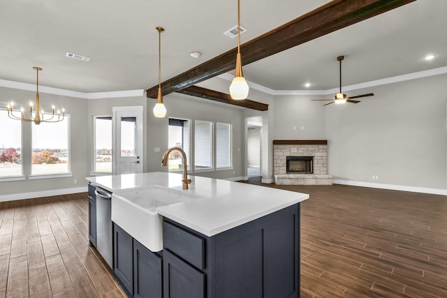 kitchen with sink, dark hardwood / wood-style flooring, stainless steel dishwasher, a kitchen island with sink, and ceiling fan with notable chandelier