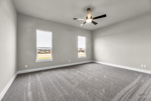 carpeted spare room with a wealth of natural light and ceiling fan