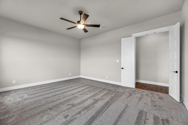 unfurnished bedroom with ceiling fan and dark colored carpet