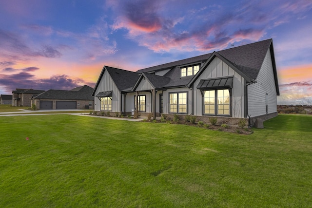 modern farmhouse style home featuring a lawn and a garage