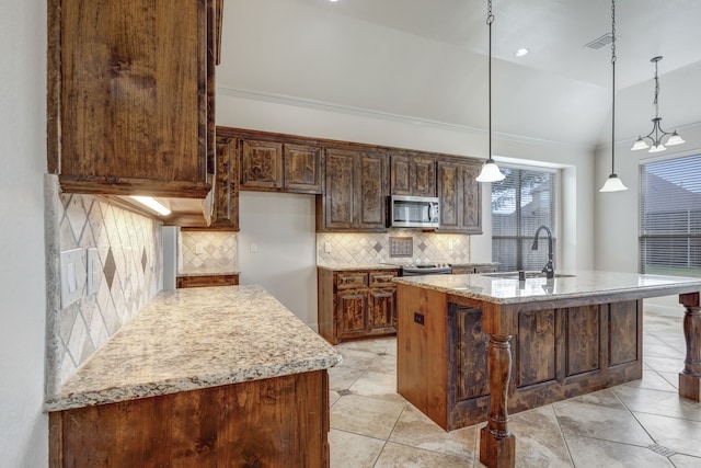 kitchen with a kitchen island with sink, lofted ceiling, sink, pendant lighting, and tasteful backsplash