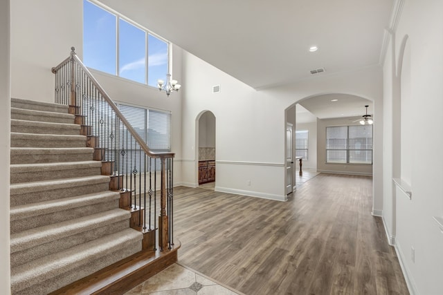 foyer entrance featuring ceiling fan with notable chandelier and hardwood / wood-style floors