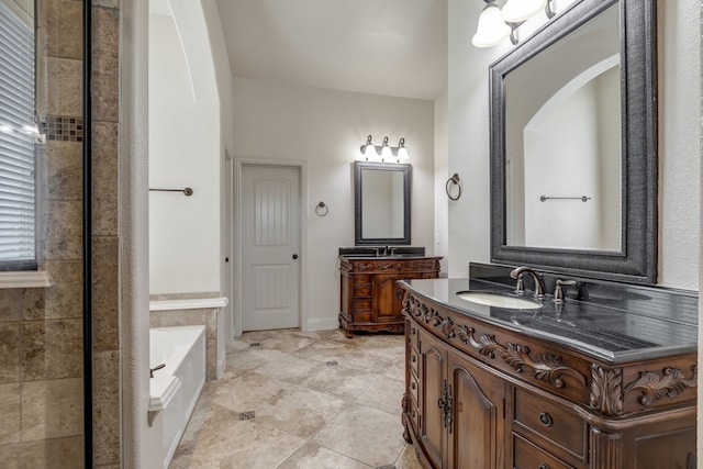 bathroom with tiled tub and vanity