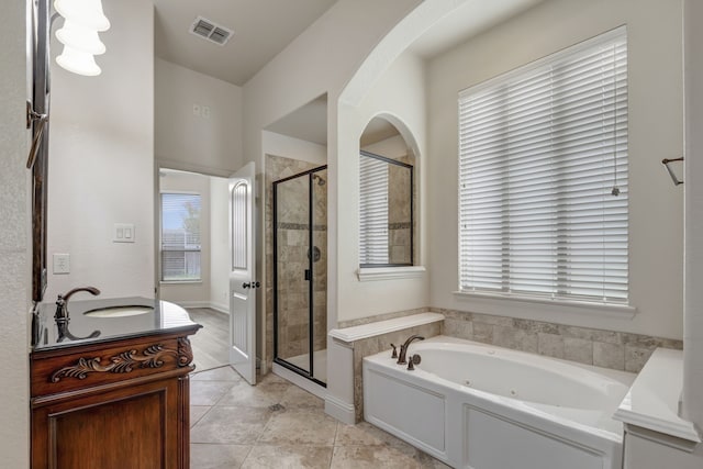 bathroom with vanity, a healthy amount of sunlight, plus walk in shower, and tile patterned floors