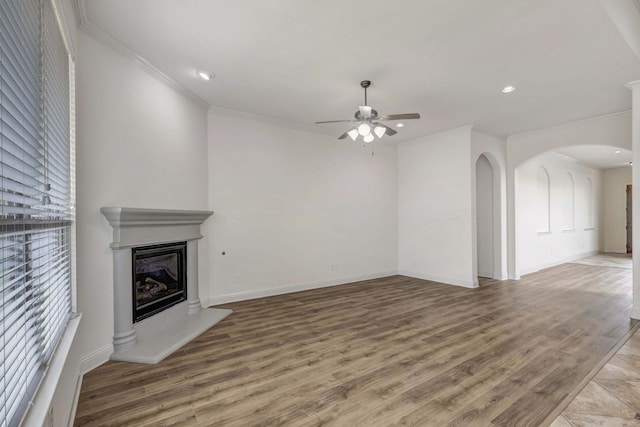 unfurnished living room featuring hardwood / wood-style floors, ceiling fan, and ornamental molding