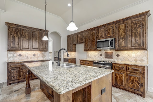 kitchen featuring a kitchen island with sink, vaulted ceiling, sink, light stone countertops, and appliances with stainless steel finishes