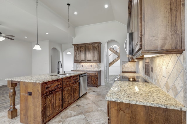 kitchen with backsplash, appliances with stainless steel finishes, sink, an island with sink, and ceiling fan