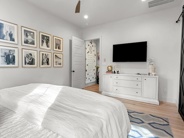 bedroom with light hardwood / wood-style floors and ceiling fan