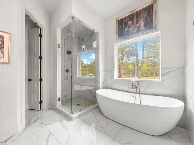 bathroom with shower with separate bathtub and tile walls