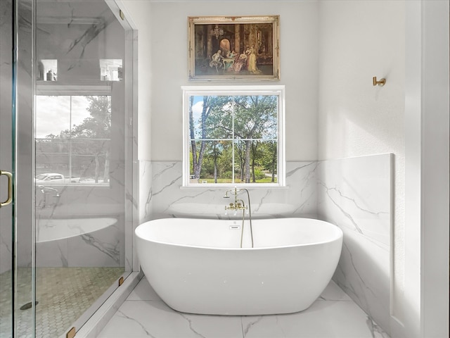 bathroom featuring plus walk in shower and tile walls