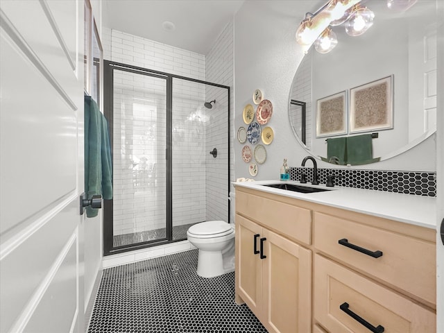 bathroom featuring tile patterned flooring, vanity, toilet, and a shower with shower door