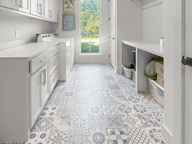 laundry area with cabinets, washing machine and clothes dryer, and light tile patterned flooring