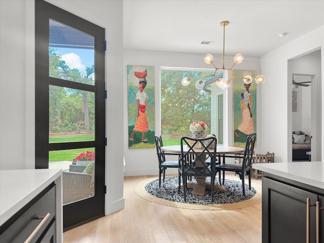 dining area with light hardwood / wood-style flooring and a chandelier