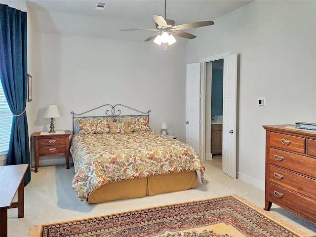 bedroom featuring ensuite bath, ceiling fan, light carpet, and lofted ceiling